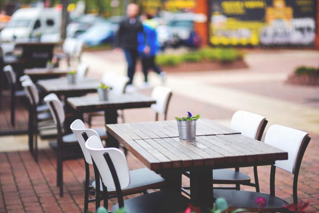 Empty outdoor café tables on a sidewalk, good for dining with a dog